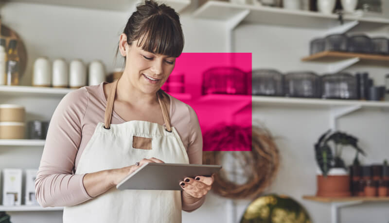 A person with an apron on looking down at a tablet